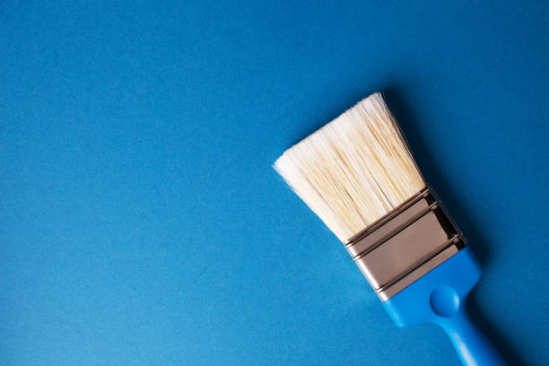 istock Paint brush on a blue background, repair concept, right orientation. 1221889551