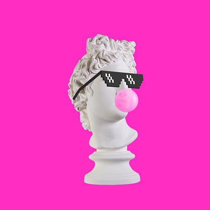 Estatua sobre un fondo rosa. Estatua de yeso de la cabeza de Apolo. Hombre creativo. Estatua de yeso de la cabeza de Apolo en gafas de píxeles. Arte conceptual minimalista. photo