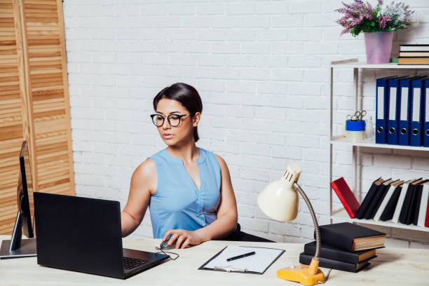 istock business girl sits in an Office behind a desk with a computer 1221891809