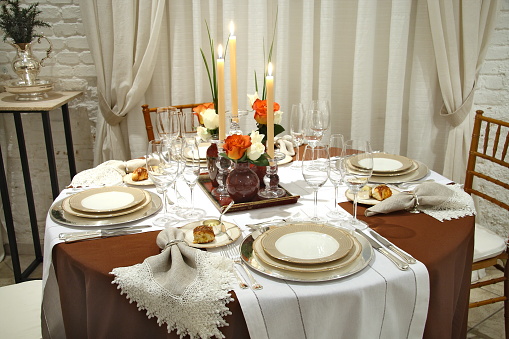 tables set up with sophisticated dishes, cutlery, glasses and flowers