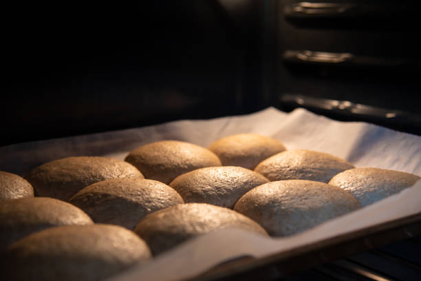 istock Pan of whole wheat buns rising in warm oven before baking 1221902492