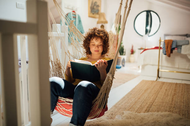 Young woman home alone with herself, reading a book