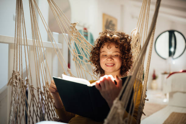 istock Young woman home alone with herself, reading a book 1221902757
