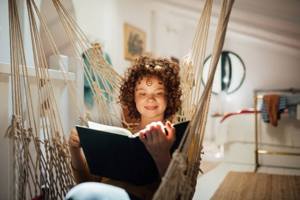 istock Young woman home alone with herself, reading a book 1221902781