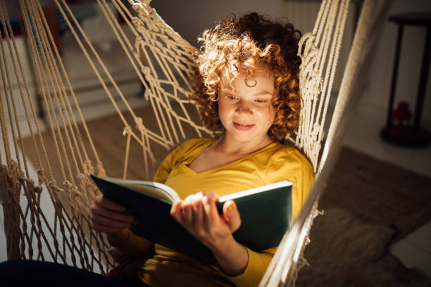 istock Young woman alone with herself, reading a book 1221902784