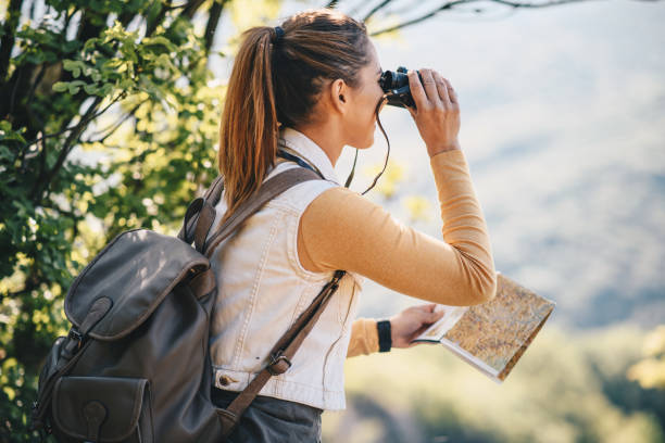 istock Woman looking through the binoculars in the forest. 1221903650