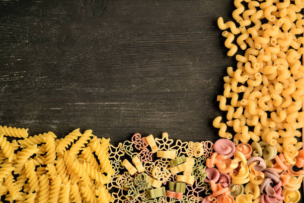 istock Different types of  raw pasta on a wooden dark table 1221903719