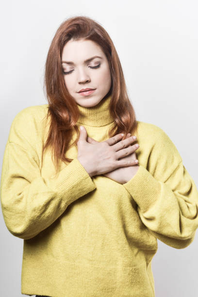 istock Calm young woman with hands on chest 1221903795