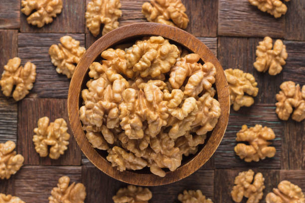 istock walnut peeled in wooden bowl, top view. 1221907340