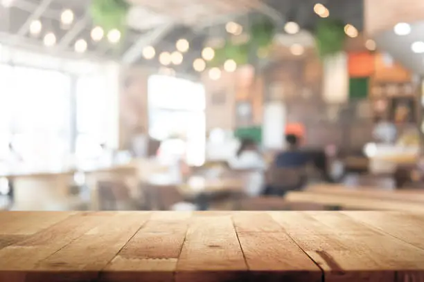 Photo of Wood table top on blur restaurant interior background
