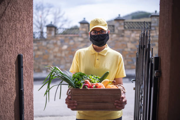 istock Woman With Protective Face Mask Delivering Vegetables During Quarantine 1221914365