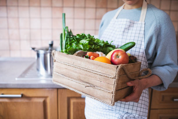 istock Woman In The Kitchen Holding Crate With Mixed Vegetables. 1221914377