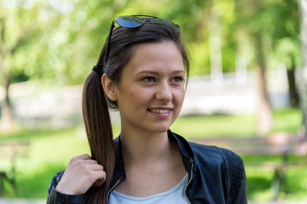 istock A woman uses a phone in a park 1221914628