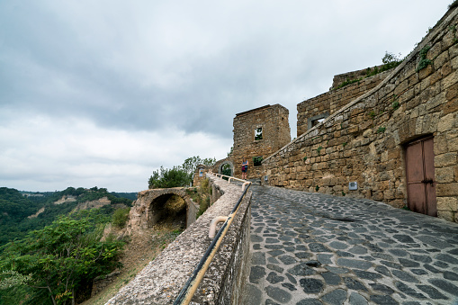 Pedestrian footbridge leading to CivitÃ  di Bagnoregio, Civita Bagno, an ancient Etruscan  hiulltop village perched atop volcanic tufta rock in southern Tuscany that is slowly eroding. Called the dying town because homes and a palace have collapsed and slid to the bottom of the valley in the eroding clay, Tuscany, Italy, Europe