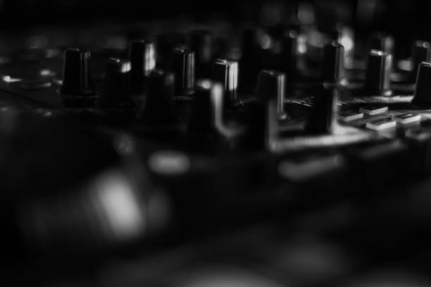 istock Blurred DJ Turn Table Jog Wheels with lots of turn knobs dark black & white Music Studio 1221917114