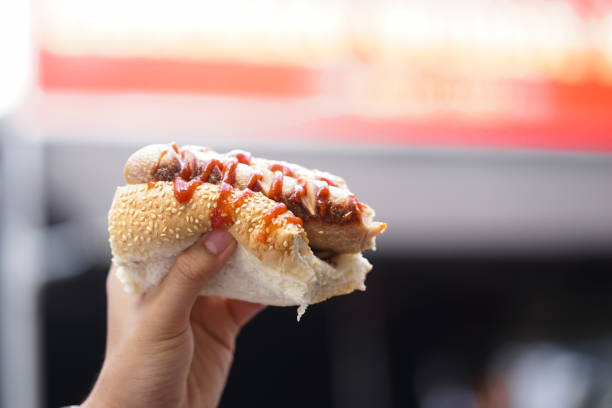 Hot dog. A hand holding half bite hot dog. stock photo