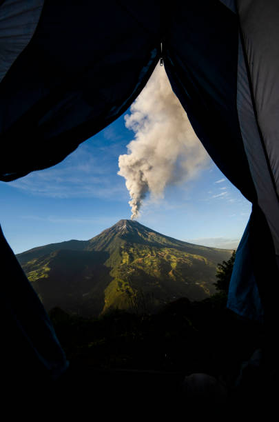 Tungurahua volcano, ecuador Tungurahua,  5,023 meters (16,480 ft) is located in the Cordillera Oriental of the Andes of central Ecuador according to one theory the name Tungurahua is a combination of the Quichua tunguri (throat) and rahua (fire) meaning "Throat of Fire". According to another theory it is based on the Quichua uraua for crater.  Tungurahua is also known as "The Black Giant" and, in local indigenous mythology it is allegedly referred to as Mama Tungurahua ("Mother Tungurahua"). mt tungurahua sunset mountain volcano stock pictures, royalty-free photos & images