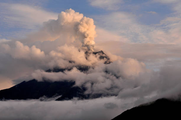Tungurahua volcano, ecuador Tungurahua,  5,023 meters (16,480 ft) is located in the Cordillera Oriental of the Andes of central Ecuador according to one theory the name Tungurahua is a combination of the Quichua tunguri (throat) and rahua (fire) meaning "Throat of Fire". According to another theory it is based on the Quichua uraua for crater.  Tungurahua is also known as "The Black Giant" and, in local indigenous mythology it is allegedly referred to as Mama Tungurahua ("Mother Tungurahua"). mt tungurahua sunset mountain volcano stock pictures, royalty-free photos & images