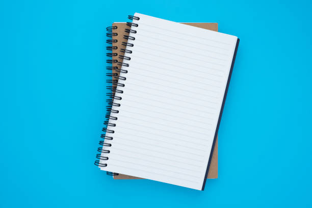 istock Top view above of two spiral notebooks that open and close, stacked isolated on light blue background for design a mockup. Education and business concept. flat lay 1221925345