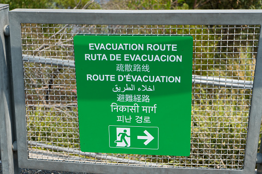 Photo of a green emergency evacuation sign in multiple languages