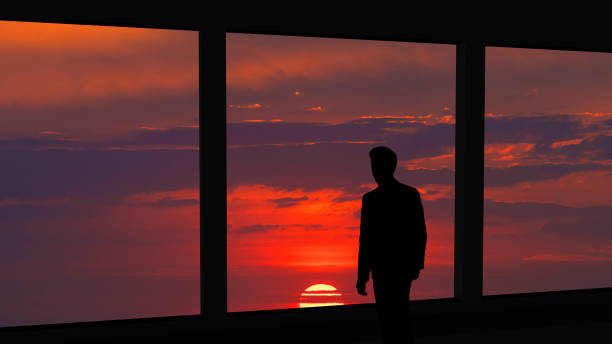 istock The man standing near the panoramic window on the beautiful sunset background 1221927986