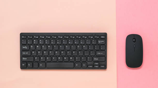 istock Wireless keyboard on a pink background and wireless mouse on a red background. 1221929886