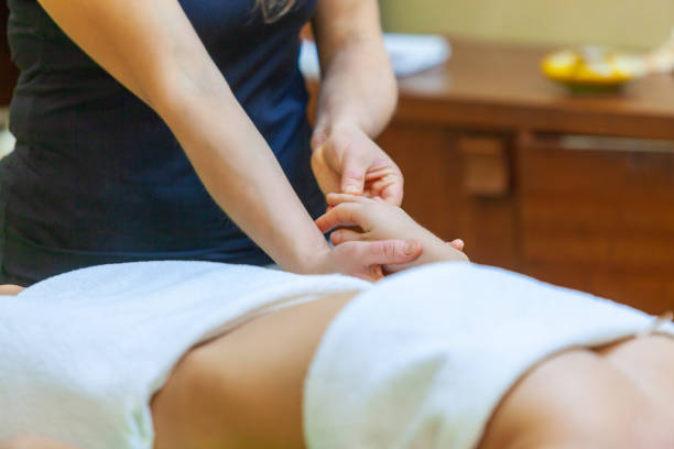 istock Close-up of massage therapist hands massaging her clients hands 1221934372