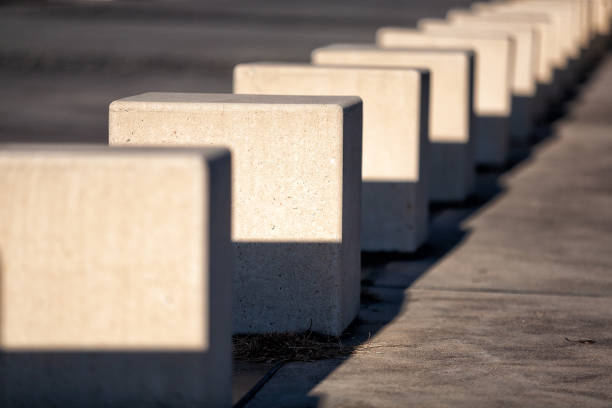 View of a row of square concrete traffic barriers separating a road from pedestrian walkways on the foreshore of Lake Burley Griffin Canberra