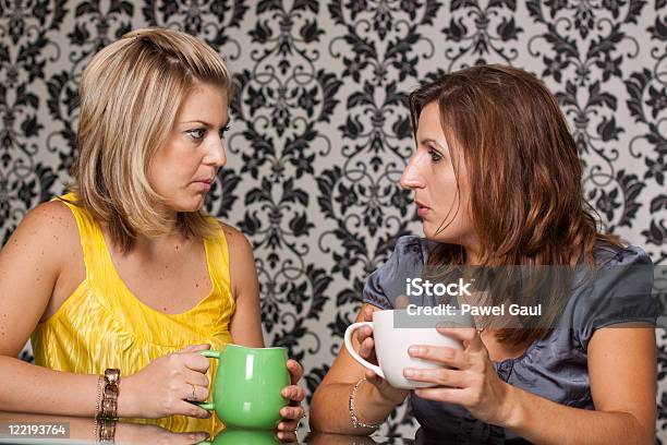 Duas Mulheres Com Graves Conversão Sobre O Copo De Café - Fotografias de stock e mais imagens de Adulto