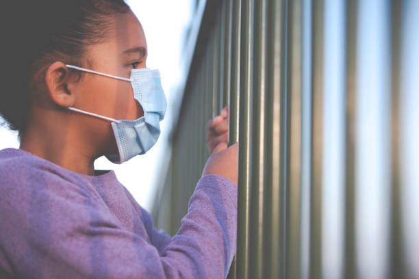 il distanziamento sociale deriva dalle ricadute psicologiche del bambino. - fence mask foto e immagini stock