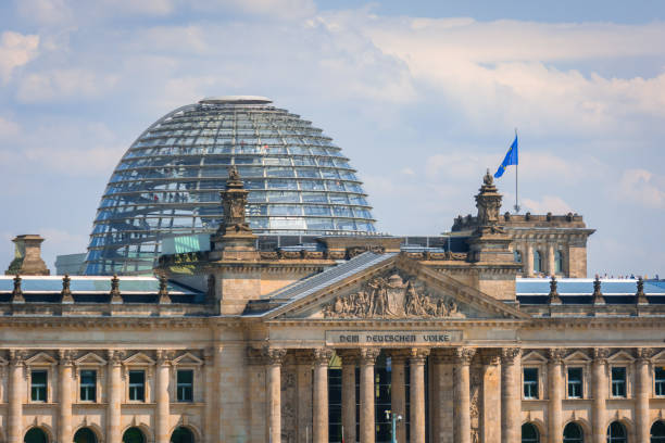 Berlin Reichstag building reflecting in window pane at sunny winter day