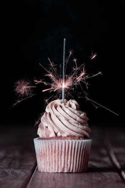 istock One cupcakes on a table with a sparkle and a black background 1221946382