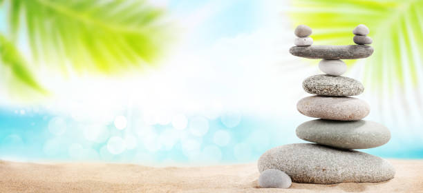 istock Pyramid of sea pebbles on a sunny sand beach 1221946778