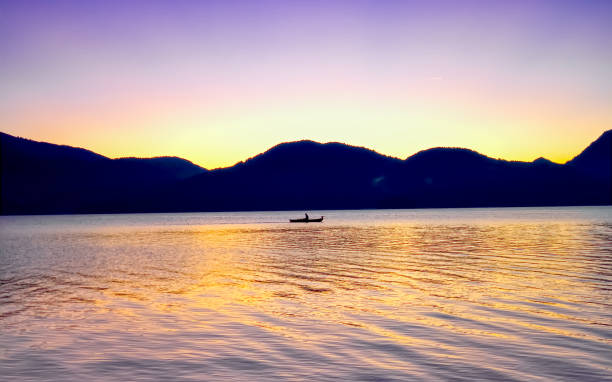 a single fisherman is rowing over a lake