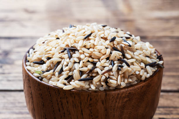 木製のボウルに生の野生の米。木製の背景に生の米グリット。スペースをコピーします。 - carbohydrate rice cereal plant uncultivated ストックフォトと画像