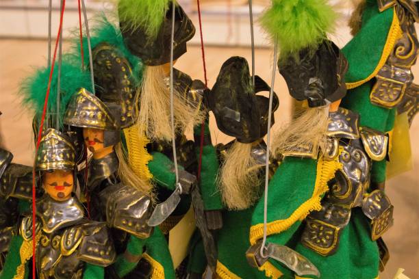istock group of puppets hanging with green threads 1221949706