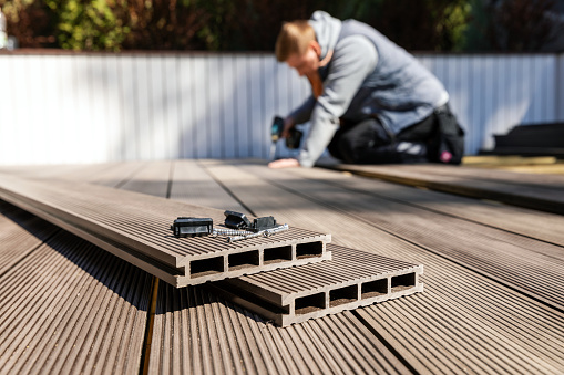 wpc terraza construcción - trabajador instalando madera de plástico tableros de cubierta suptuito photo