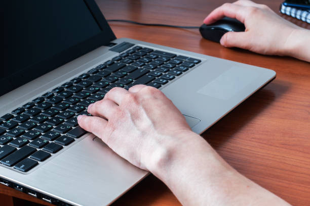 istock Working wooden table at home or in the office. Woman working at computer hands 1221951437