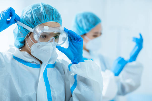 doctors wear protective suits female medical worker wear protective suits and ready to take care of coronavirus patient in isolation room protective glove photos stock pictures, royalty-free photos & images