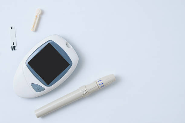 istock Electronic blood glucose meter, lancet and test strip to determine blood sugar. White background. 1221955149