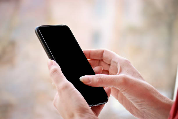istock Female hand with smartphone, black blank screen with copy space. 1221956493