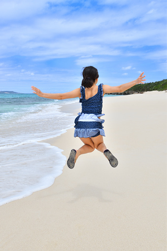 Japanese girl jumping in the beach