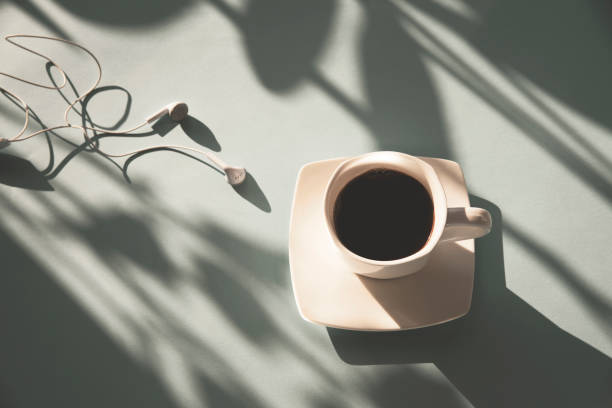 uma xícara de café e fones de ouvido à luz do sol, vista superior - fresh coffee audio - fotografias e filmes do acervo