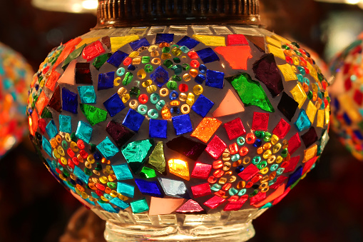 Stock photo showing illuminated Moroccan style lanterns lamp suspended from ceiling.