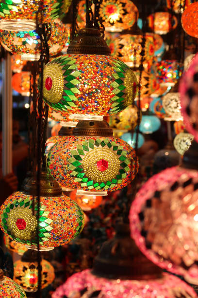 istock Image of many colourful, mosaic glass sphere lights hanging suspended from ceiling against dark background, illuminated glowing Moroccan style lanterns interior lighting 1221961663