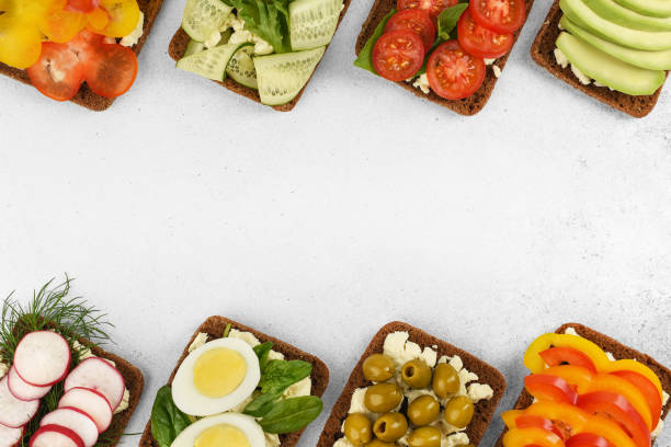 istock Top view frame open faced vegetarian sandwiches on stone background. 1221961679