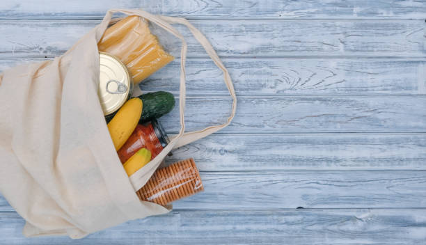 istock Textile bag with different food on wooden background 1221964109