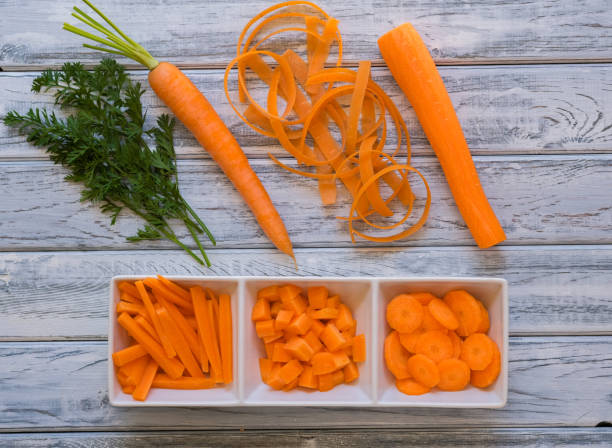 istock Fresh sweet carrot on light wooden background with different cuts 1221964126
