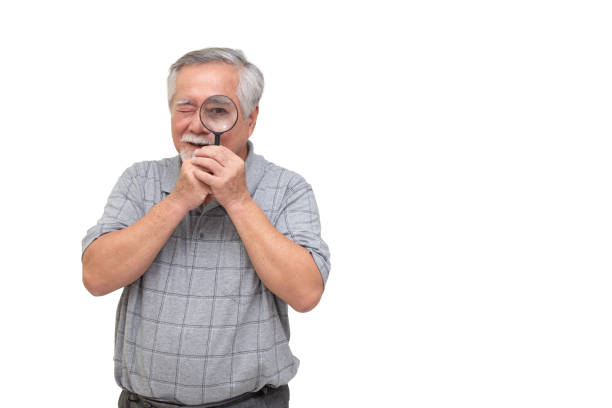 istock Senior Asian man looking through magnifying glass and smiling isolated on white background 1221965680