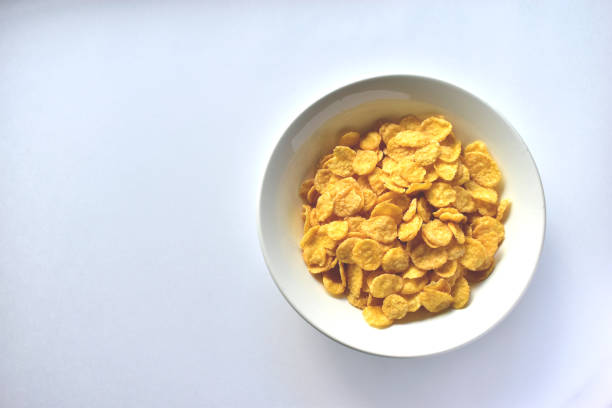 istock A Cup of yellow cornflakes in milk on a white background. 1221968678
